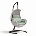 Hanging chair with padded seat and back in light green woven design